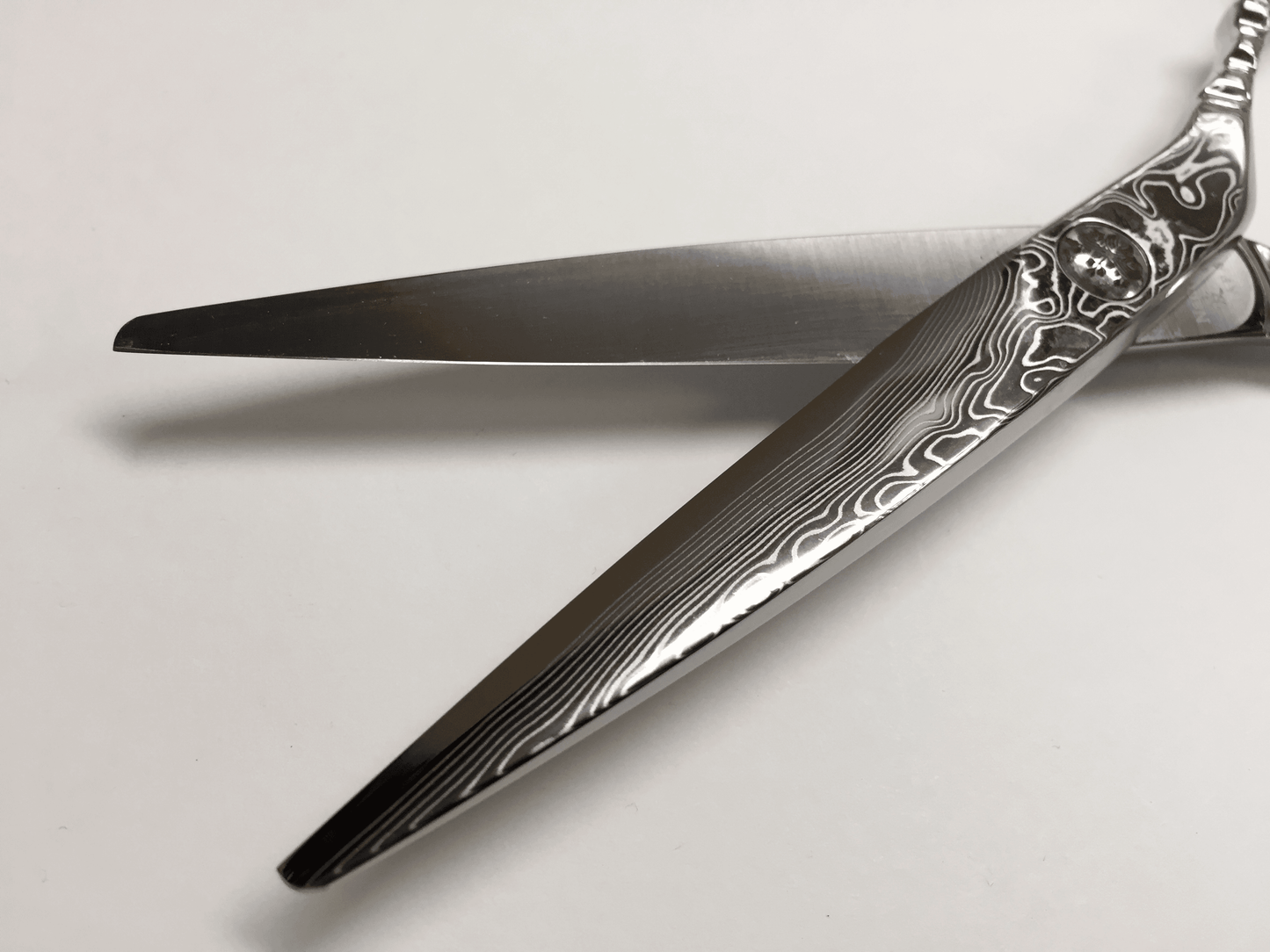 YSPARK - Klippsax Damascus Storfavoriten och saxarna lyxigaste val är Damascus. Saxen är gjort av Damascusstål och har 16 lager av hårt och mjukt stål. Den har intrigerat smide från handtaget till spetsen. Det är mindre vibrationer vid öppning och stängning för en flexibel klippning och mjukare klipp. Detta är en sax som passar till allt från exakta klippningar till uppklippningar och slide cut.