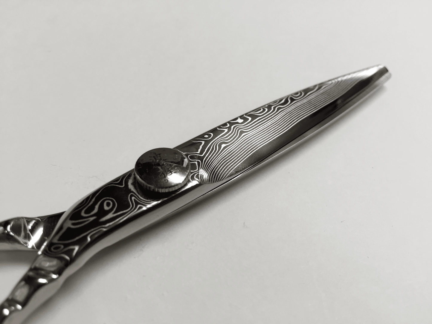 YSPARK - Klippsax Damascus Storfavoriten och saxarna lyxigaste val är Damascus. Saxen är gjort av Damascusstål och har 16 lager av hårt och mjukt stål. Den har intrigerat smide från handtaget till spetsen. Det är mindre vibrationer vid öppning och stängning för en flexibel klippning och mjukare klipp. Detta är en sax som passar till allt från exakta klippningar till uppklippningar och slide cut.